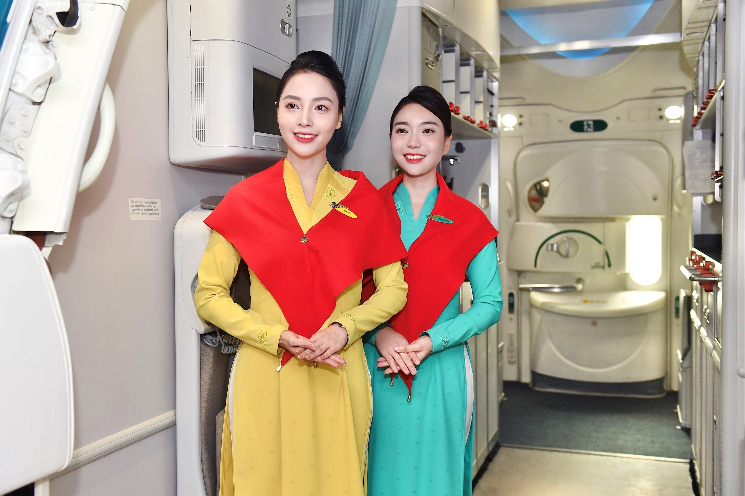 Ảnh 2. Tiếp viên Vietnam Airlines quàng khăn đỏ sao vàng, nở nụ cười chào đón hành khách trong không khí lễ hội. Ảnh VNA