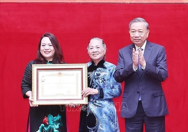 Party General Secretary To Lam (right) presents the title of Hero of the People's Armed Forces to the family representatives of Senior Lieutenant General Bui Thien Ngo. (Photo: VNA) hero-title.jpg