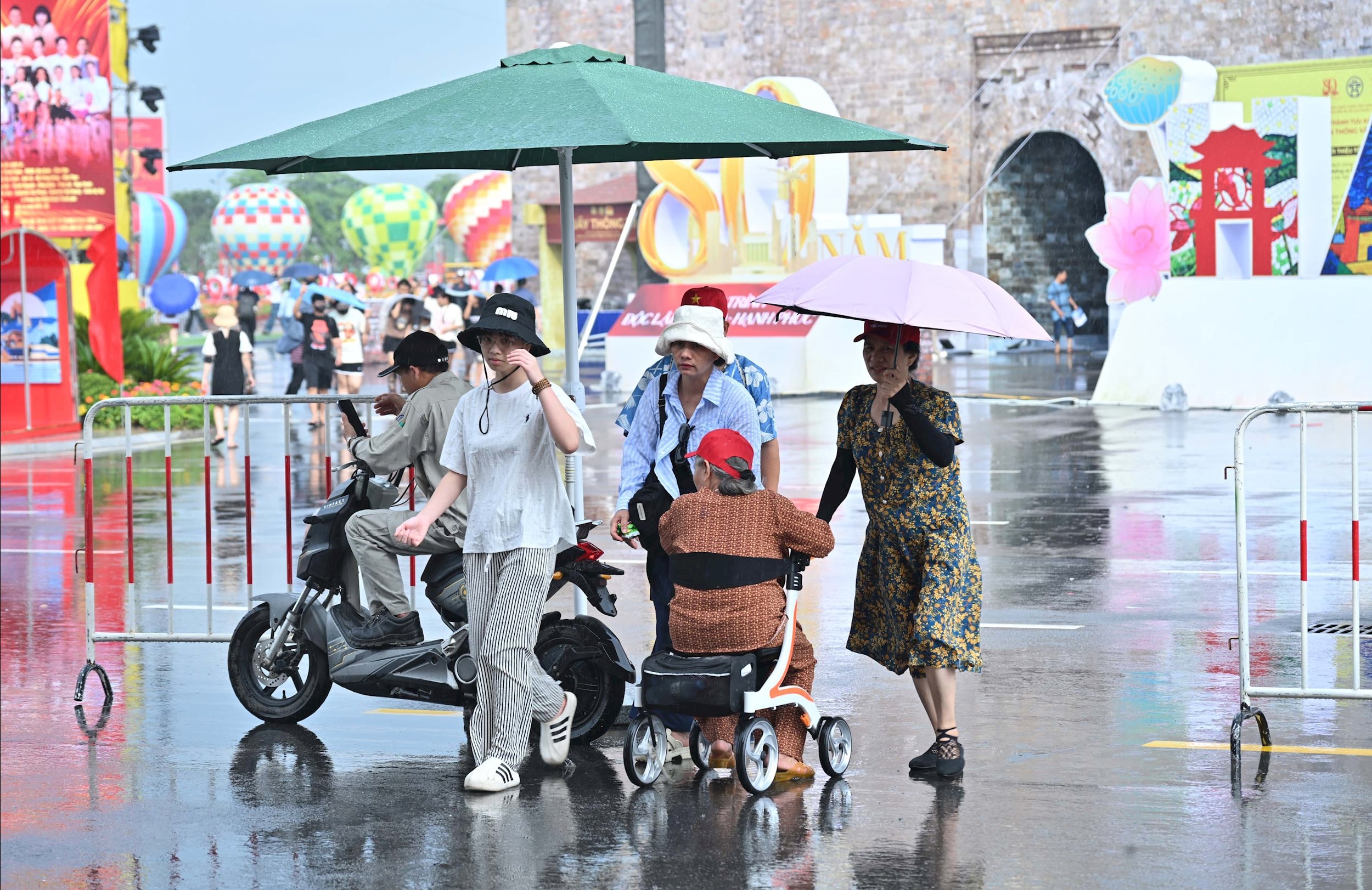 Người dân đội mưa đến tham quan Triển lãm Thành tựu Đất nước với chủ đề %2280 năm Hành trình Độc lập - Tự do - Hạnh phúc%22VQK_3864