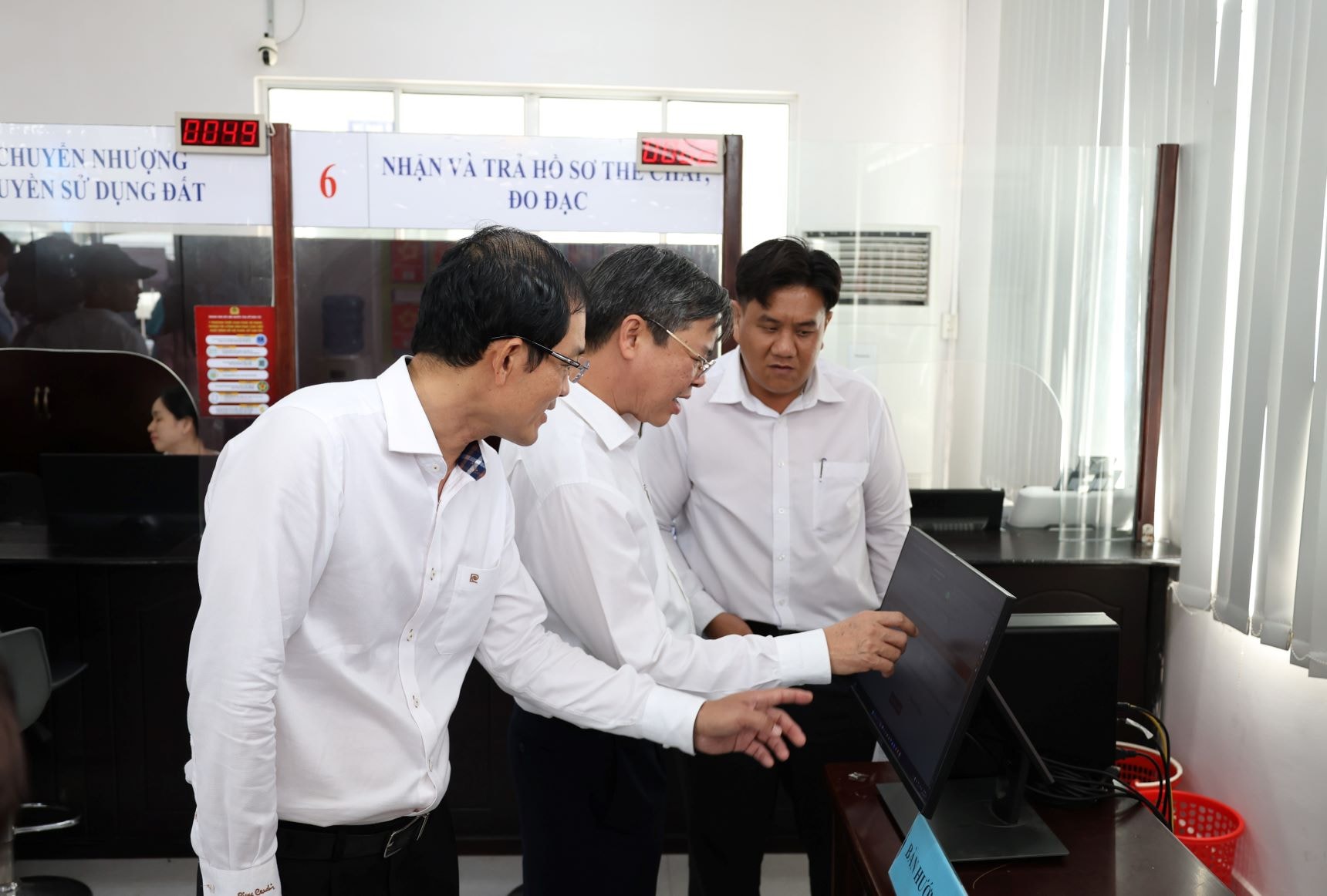 Phó Bí thư Thành ủy và cán bộ thao tác tìm hiểu về nộp hồ sơ online tại phường Phú Lợi, TP. Cần Thơ; ảnh Nguyễn Hành