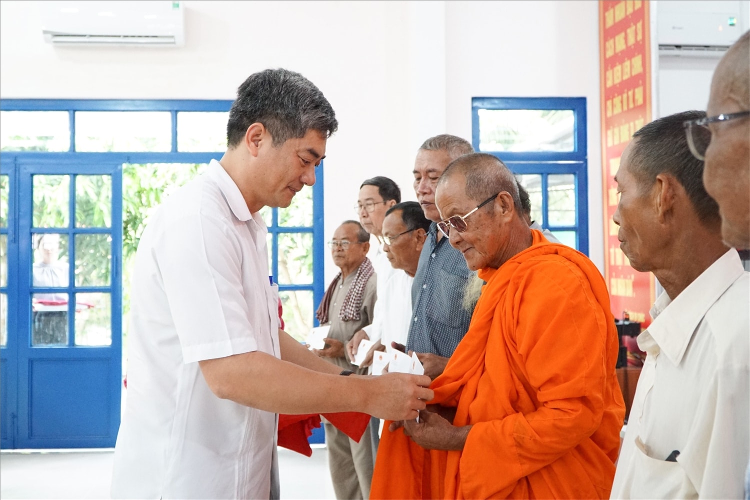Thứ trưởng Bộ Dân tộc và Tôn giáo Y Vinh Tơr thăm hỏi, tặng quà cho các hộ nghèo tại xã An Cư. Ảnh Tào Đạt