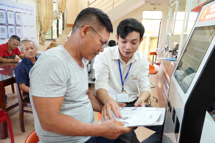 An official guides local residents in carrying out administrative procedures in Quang Ngai province. (Photo: VNA)