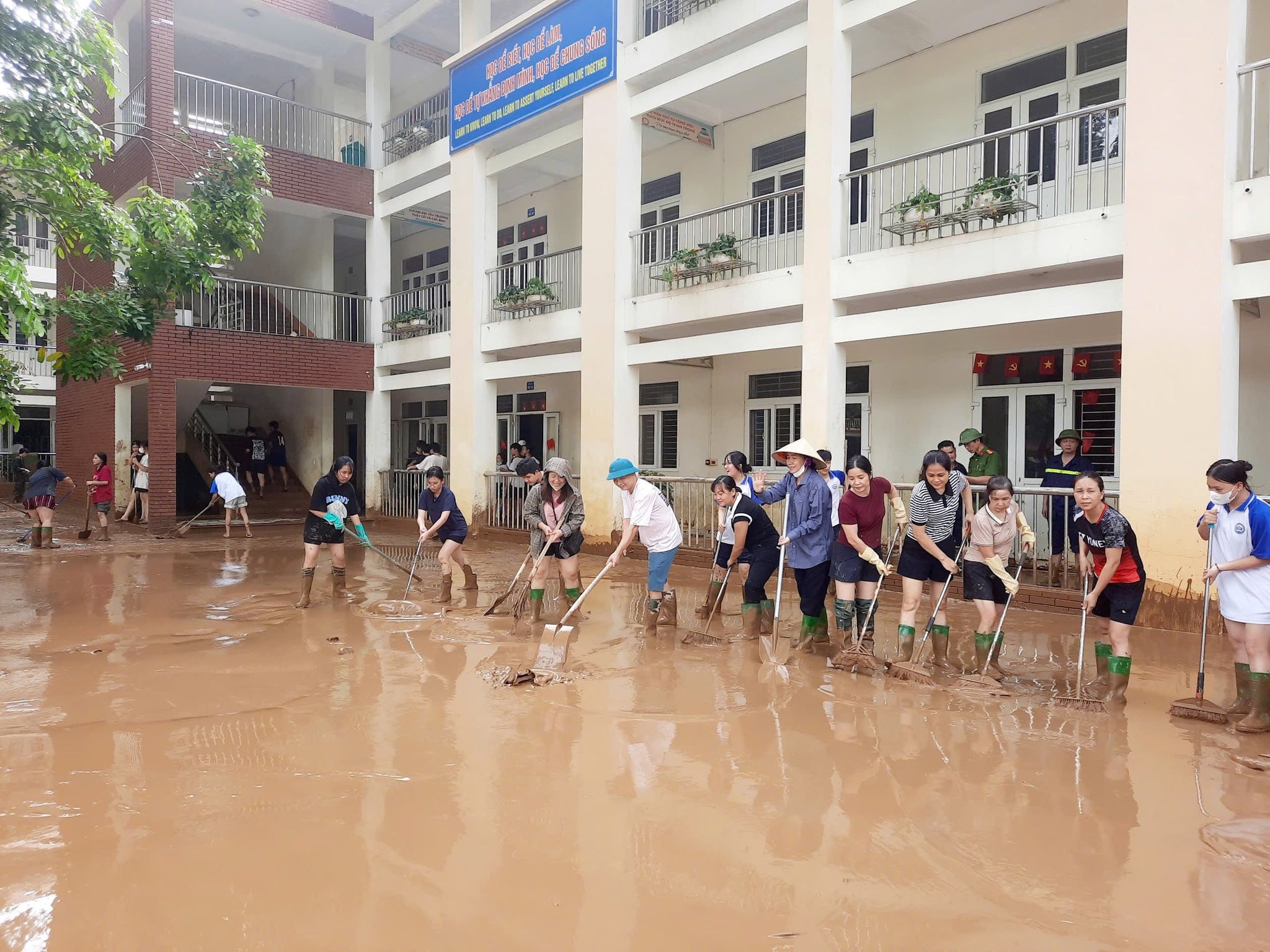 Các thầy cô giáo và các em học sinh trường THPT Nguyễn Huệ tham gia hỗ trợ dọn dẹp sau bão cho các đơn vị trường bạn