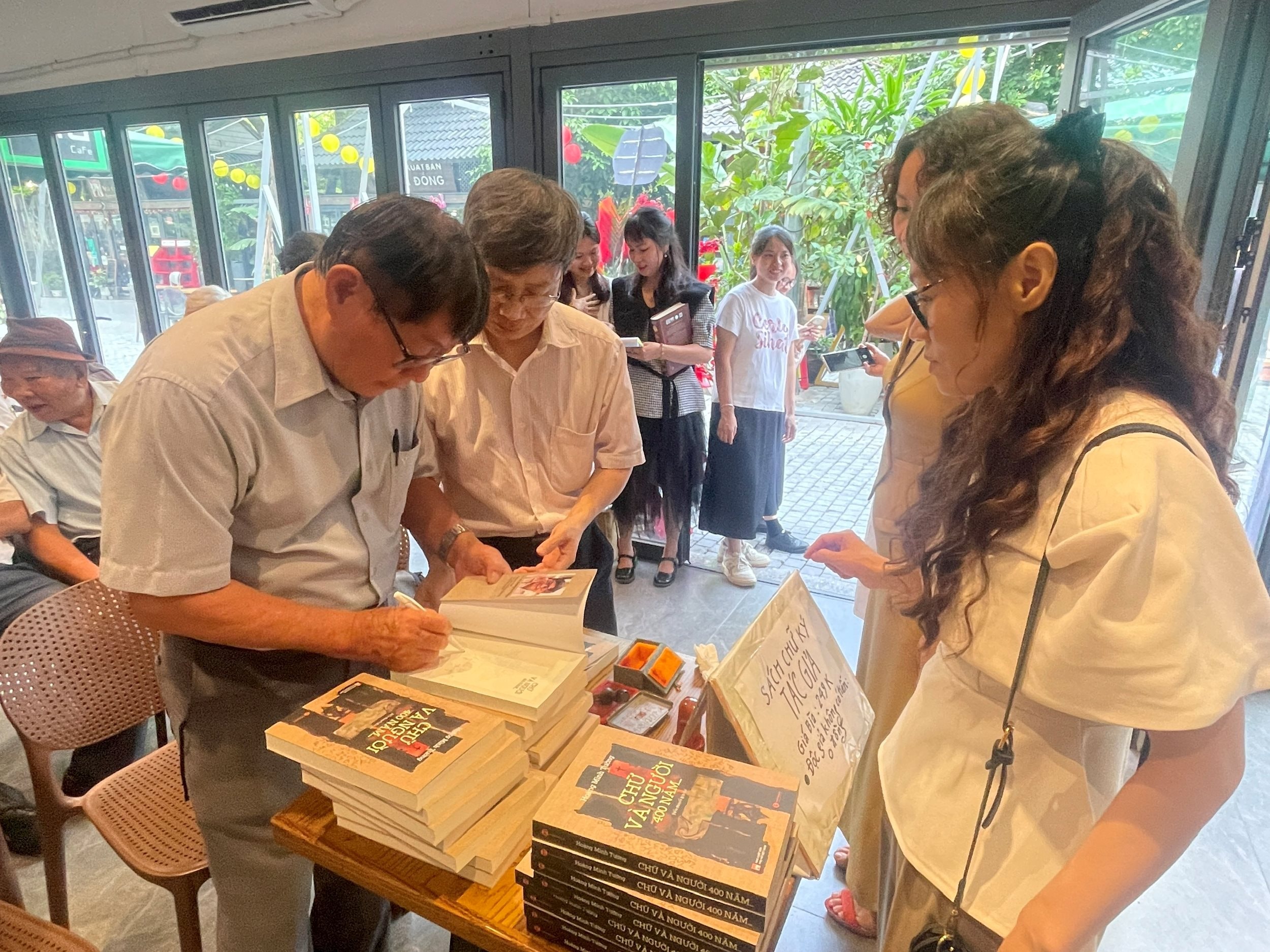 Nhà văn Hoàng Minh Tường ký tặng sách độc giả. Ảnh: HS