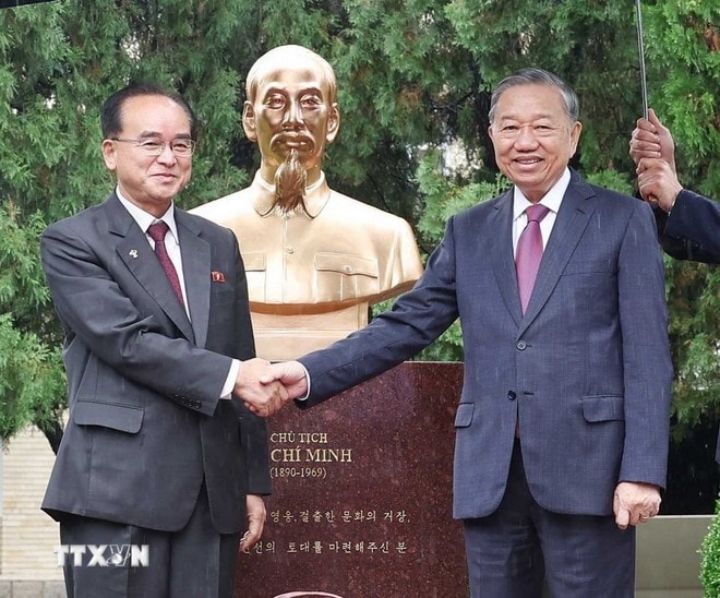 General Secretary of the Communist Party of Vietnam Central Committee To Lam (R) and Jo Yong Won, member of the Presidium of the Political Bureau, Secretary of the Central Committee, and head of the Organisation and Guidance Department of the WPK, shake hands in front of the statue. (Photo: VNA)