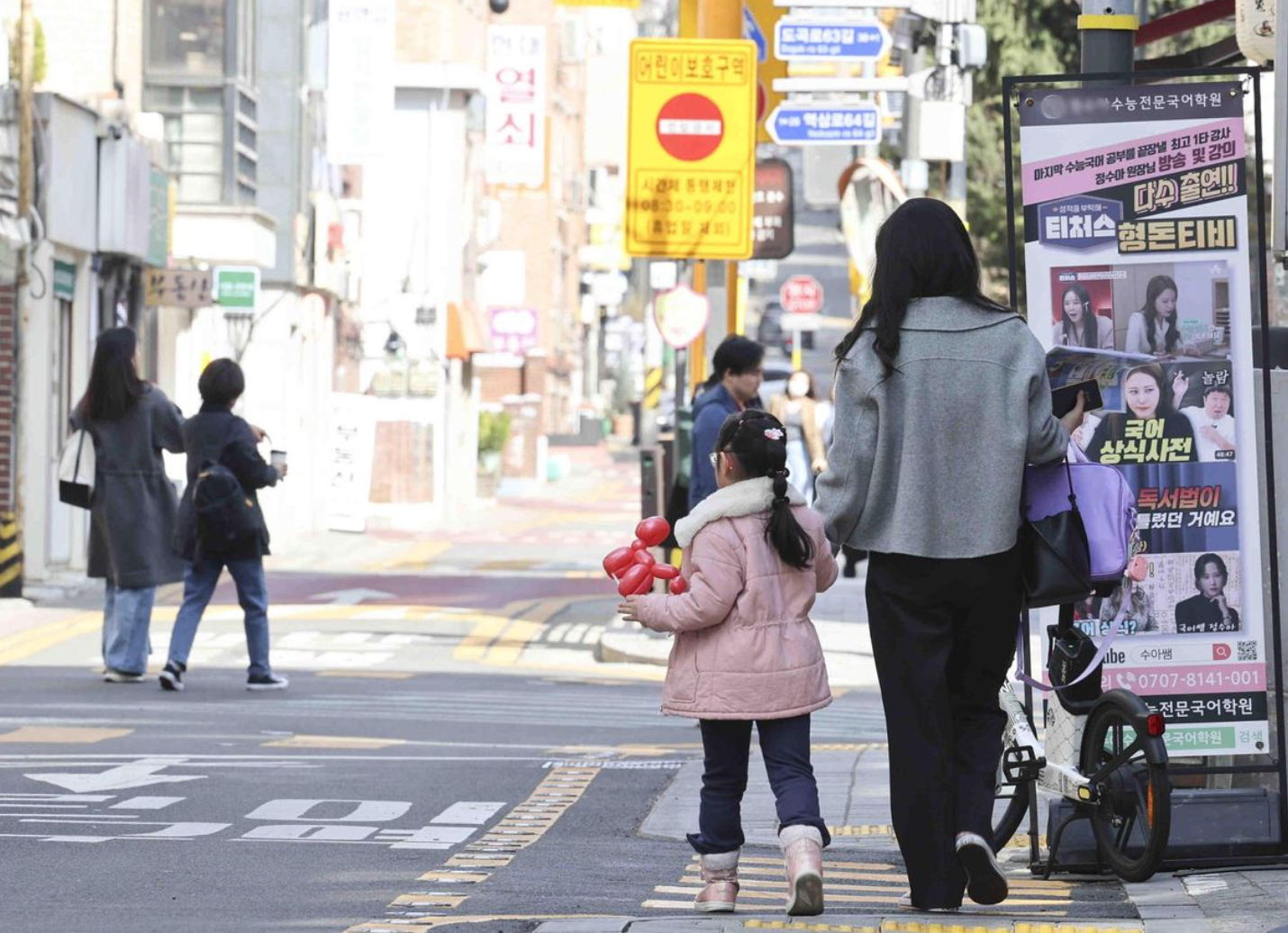 Một bé gái đi bộ cùng mẹ ở khu vực được gọi là 