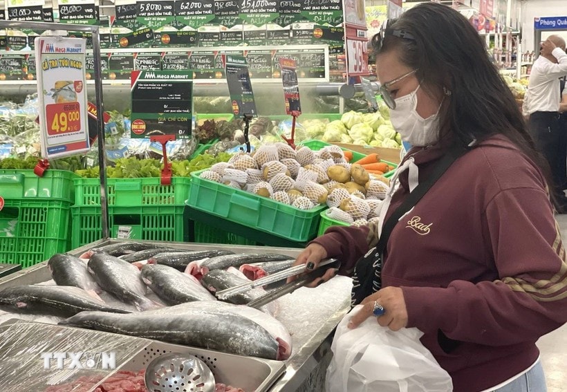 A consumer chooses seafood products at a supermarket (Photo: VNA)