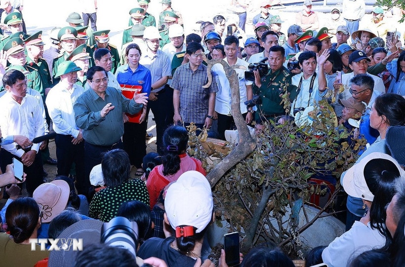Thủ tướng Phạm Minh Chính thăm hỏi, động viên các hộ dân bị ảnh hưởng bởi triều cường tại xã Đề Gi. (Ảnh: Dương Giang/TTXVN)