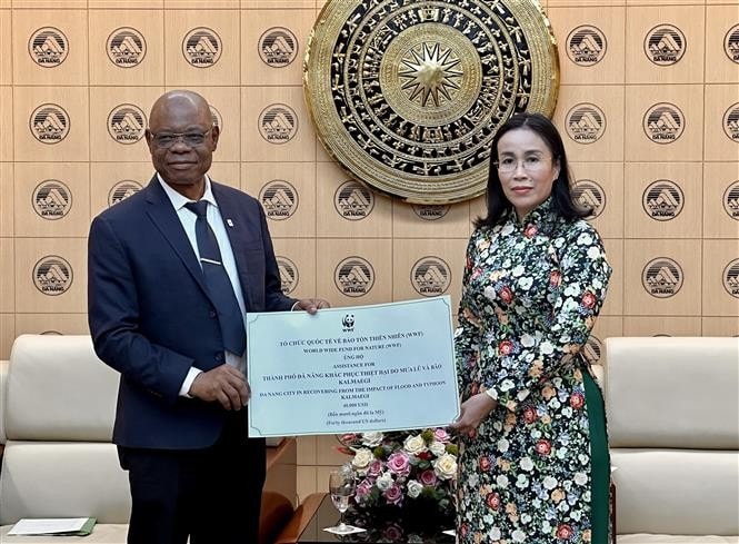 Martin Kabaluapa Kapinga (L), Chief of Country Offices Division at the World Wide Fund for Nature (WWF) presents a symbolic donation of 40,000 USD to Vice Chairwoman of the People’s Committee of Da Nang to support the central city's recovery efforts following the heavy rains and Typhoon Kalmaegi (Photo: VNA)