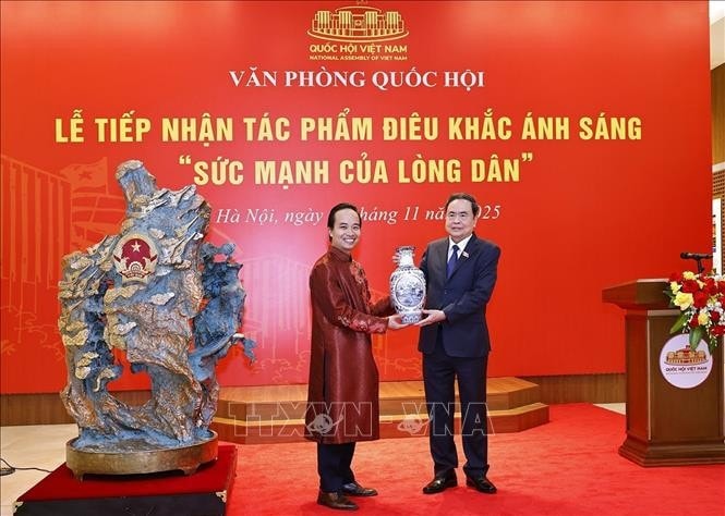 NA Chairman Tran Thanh Man presents a gift to artisan Bui Van Tu. Photo: VNA