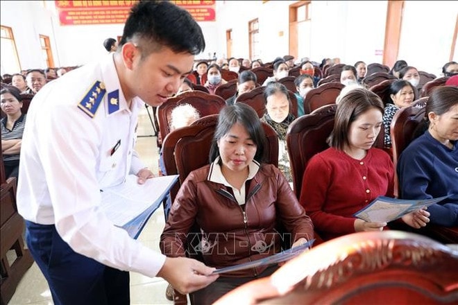 An officer of Squadron 11 under the Coast Guard Region 1 Command distributes leaflets and legal handbooks to delegates at the event. (Photo: VNA) hd2.jpg