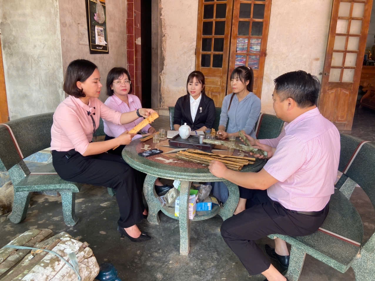 Cán bộ NHCSXH tới thăm mô hình trồng và sản xuất quế của chị Nguyễn Thị Hiến tại huyện Trấn Yên, một hộ kinh doanh bị ảnh hưởng nặng do mưa lũ. Ảnh Tùng Dương