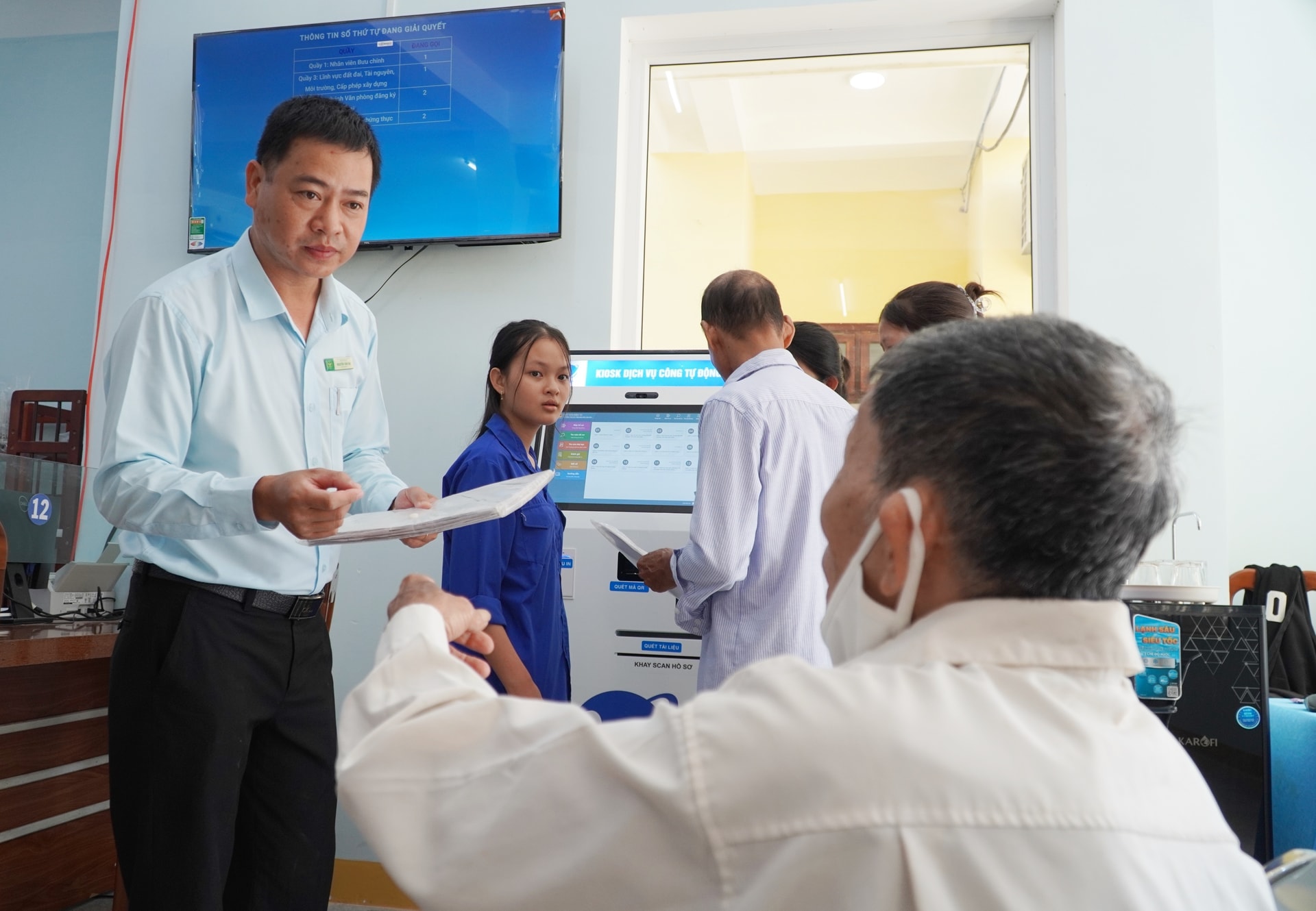 Cán bộ Trung tâm Phục vụ hành chính công phường Quảng Phú hướng dẫn công dân làm thủ tục đất đai. Ảnh N.ĐOAN