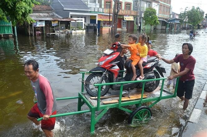 People evacuate from flooded areas after heavy rains in Semarang, Central Java, Indonesia. (Photo: Xinhua/VNA)