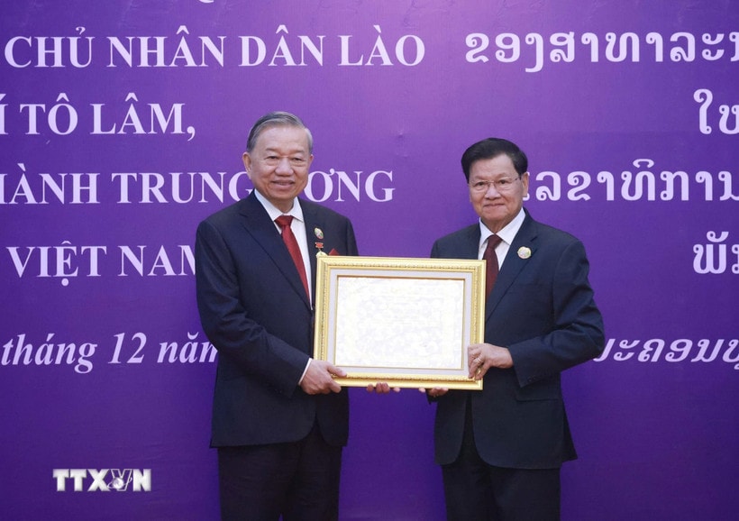 Tổng Bí thư, Chủ tịch nước Lào Thongloun Sisoulith trao tặng Huân chương Vàng Quốc gia của Nhà nước Lào cho Tổng Bí thư Tô Lâm. (Ảnh: Thống Nhất/TTXVN)
