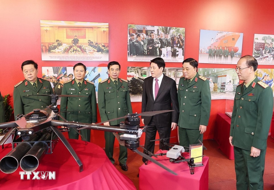 លោកប្រធានរដ្ឋ លឿង គឿង និងគណៈប្រតិភូបានទៅទស្សនាការតាំងពិព័រណ៍ឧបករណ៍ និងសម្ភារៈយោធាដែលផលិតដោយអគ្គនាយកដ្ឋានឧស្សាហកម្មការពារជាតិ។ (រូបថត៖ ឡាំ ខាញ់/VNA)