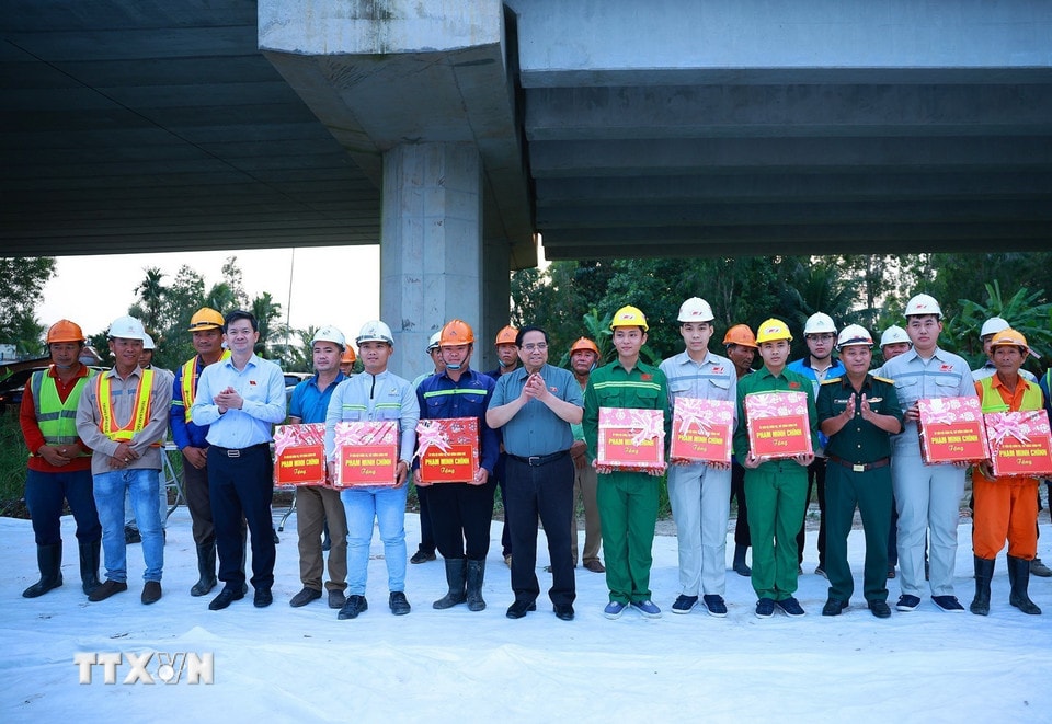 Thủ tướng Phạm Minh Chính tặng quà động viên các kỹ sư, công nhân thi công dự án cao tốc Châu Đốc-Cần Thơ-Sóc Trăng. (Ảnh: Dương Giang/TTXVN)