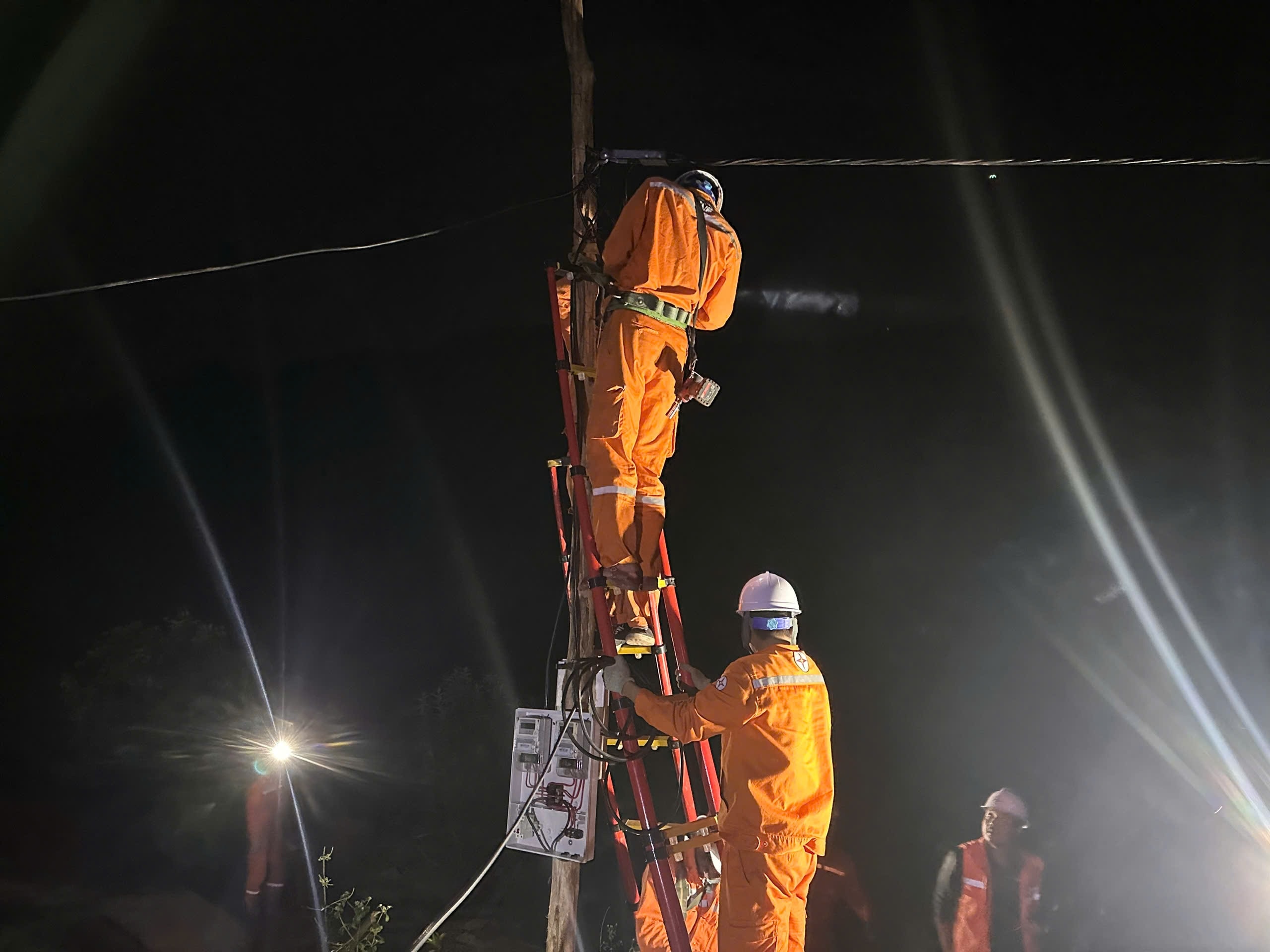 Công nhân EVNNPC thi công xuyên đêm, lắp đặt đường dây và thiết bị điện, bảo đảm tiến độ cấp điện cho thôn, bản vùng sâu, vùng xa. Ảnh NPC