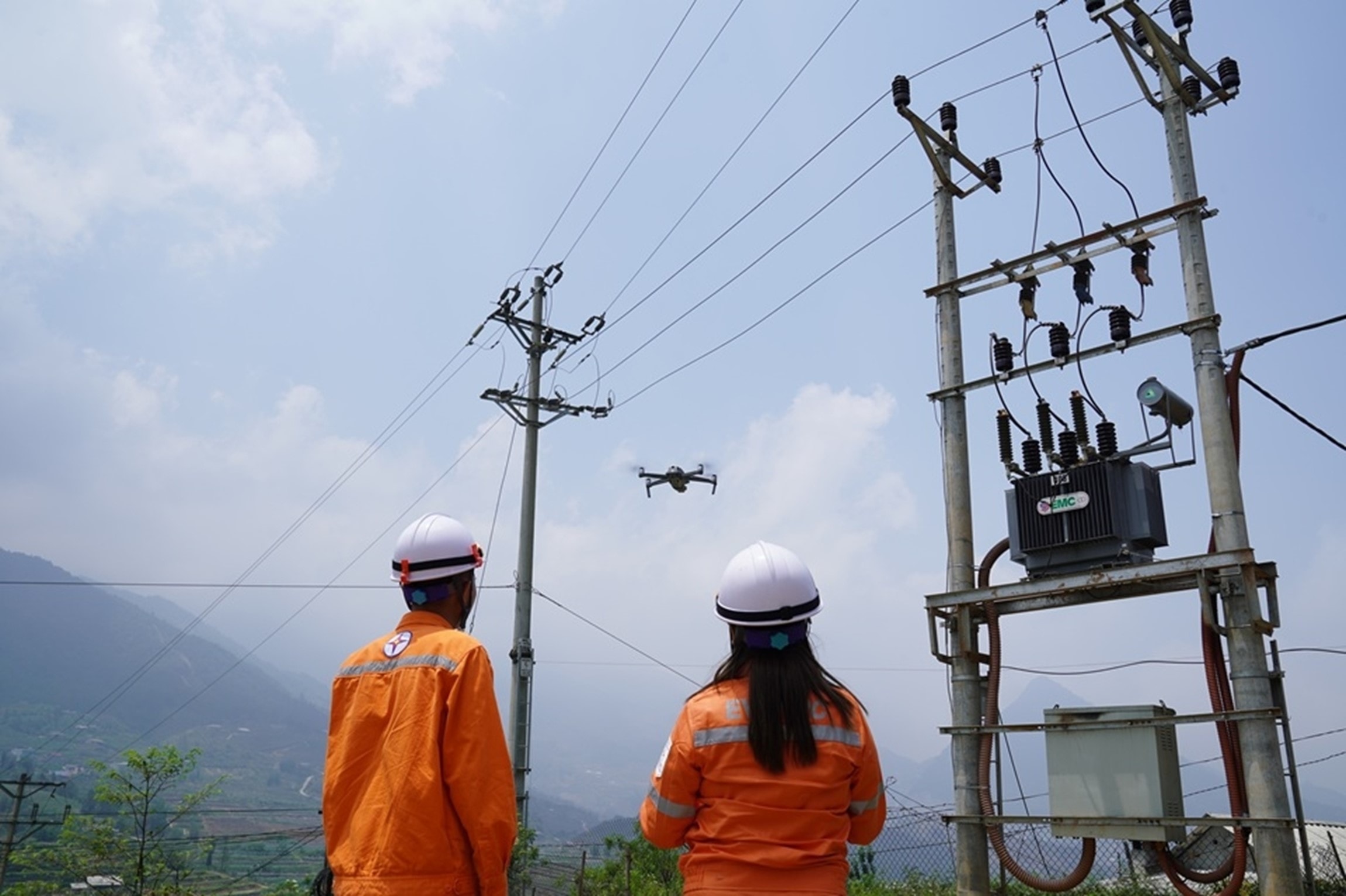 Công nhân ngành điện lực miền Bắc sử dụng thiết bị bay điều khiển từ xa trong công việc. Ảnh PV