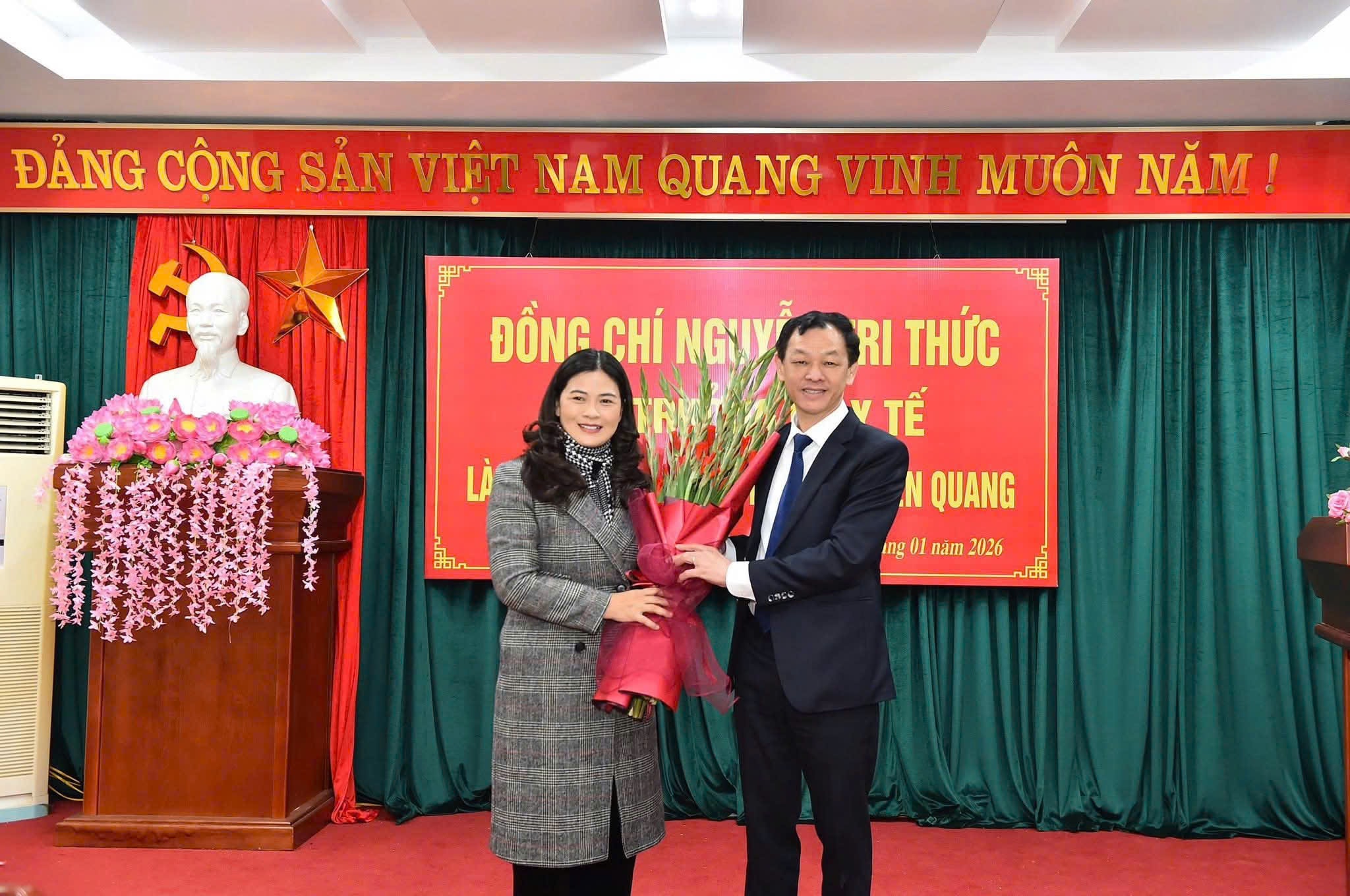 Vice ordförande för provinsens folkkommitté, Vuong Ngoc Ha, överlämnade blommor för att gratulera docent Dr. Nguyen Tri Thuc, biträdande hälsominister.