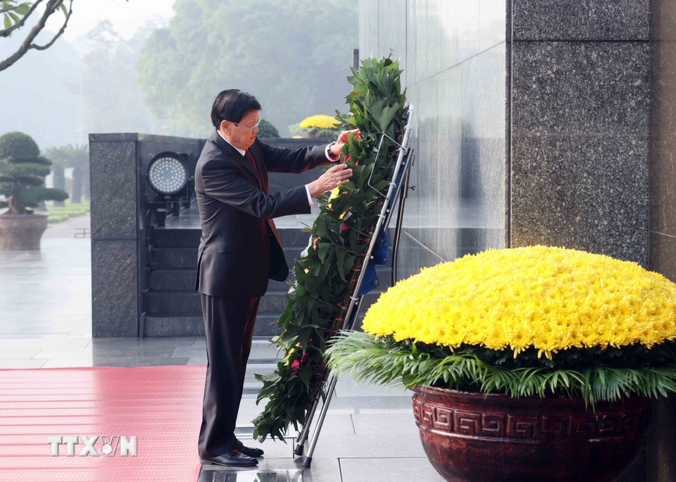 Tổng Bí thư, Chủ tịch nước Lào Thongloun Sisoulith đặt vòng hoa, vào Lăng viếng Chủ tịch Hồ Chí Minh. (Ảnh: An Đăng/TTXVN)