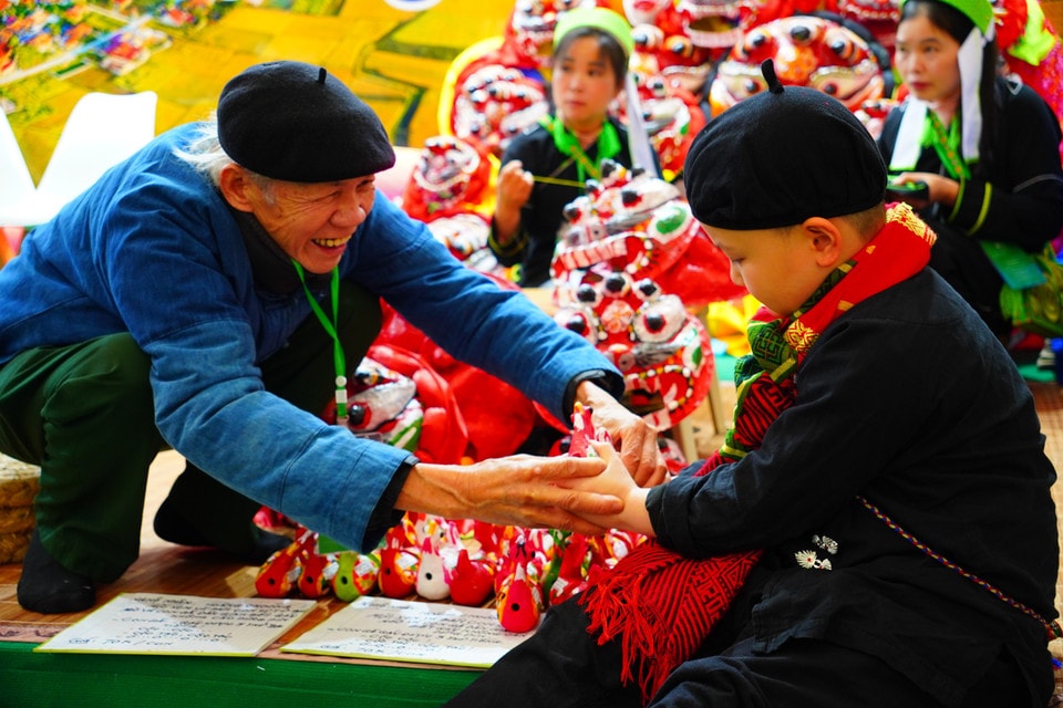 A Tay artisan introduces the traditional “folk chicken” toy. (Photo: VNA)