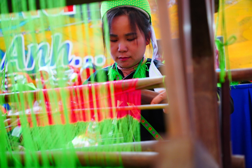 A woman in Nung ethnic costume demonstrates traditional weaving techniques at the Lang Son province booth. (Photo: VNA)