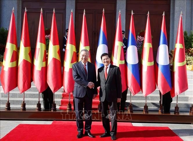 General Secretary of the Lao People’s Revolutionary Party (LPRP) Central Committee and President of Laos Thongloun Sisoulith (Right) welcomes General Secretary of the Communist Party of Vietnam (CPV) Central Committee To Lam during his state visit to Laos. (Photo: VNA)