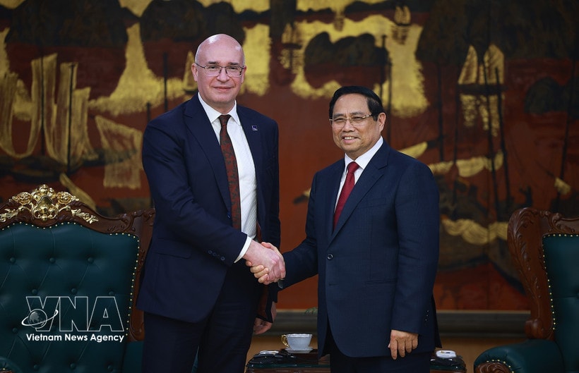 Prime Minister Pham Minh Chinh (R) welcomes TASS Director General Andrey Kondrashov (Photo: VNA)