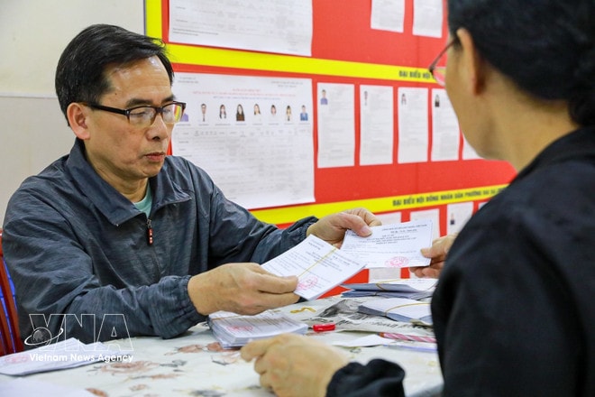Officials check and verify voter cards at Polling Station No. 3 in Hai Ba Trung ward, Hanoi. (Photo: VNA) vnanet-hai-ba-trung-hanoi.jpg