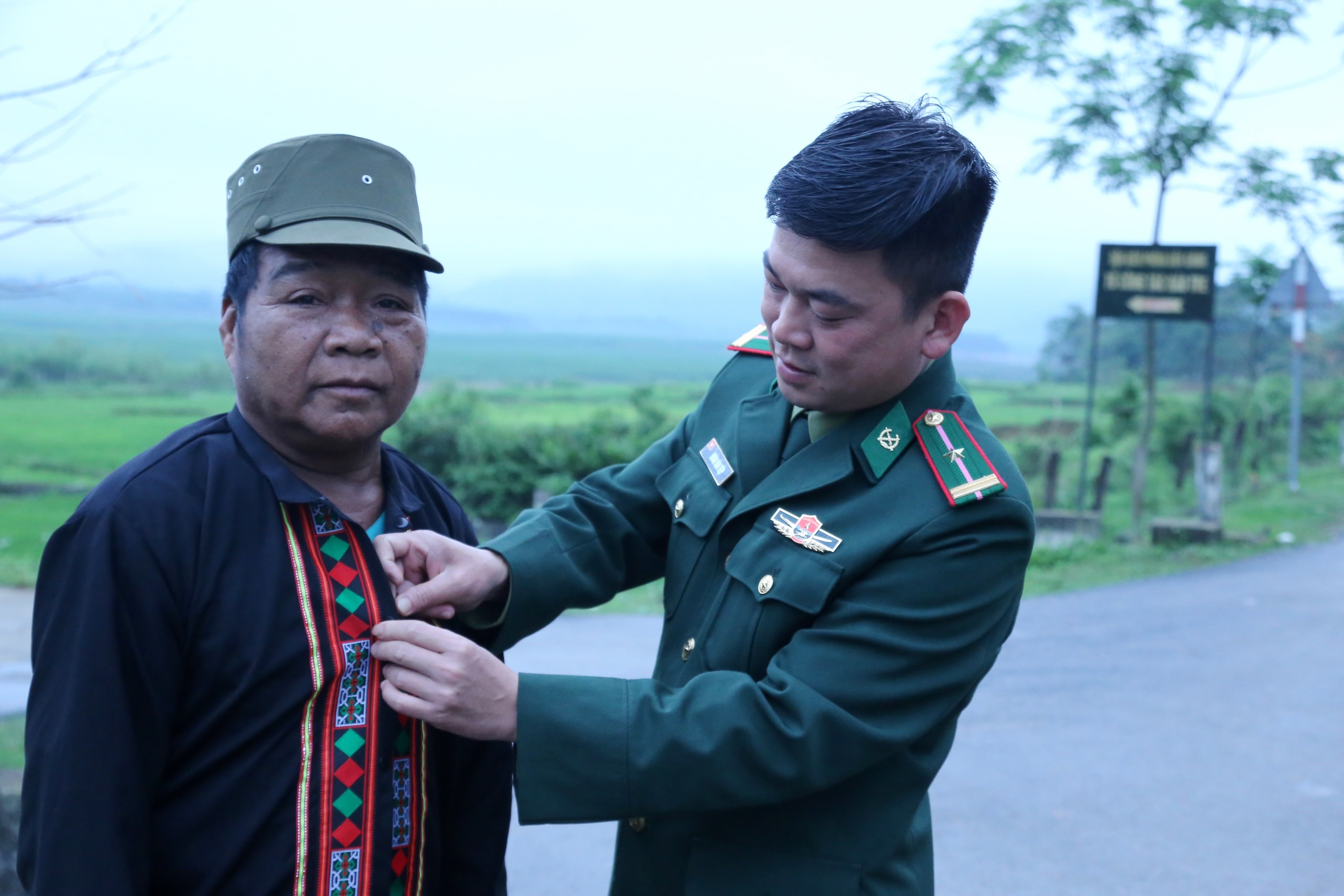Cán bộ Tổ công tác Biên phòng bản Rào Tre sửa lại áo cho bà con trước khi đi bầu cư