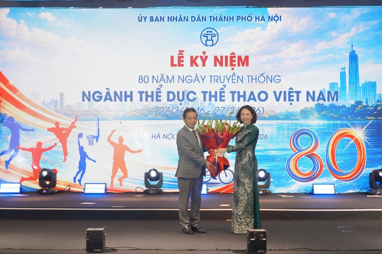 Thứ trưởng Bộ Văn hóa, Thể thao và Du lịch Hoàng Đạo Cương tặng hoa cho UBND thành phố Hà Nội Vũ Thu Hà. Ảnh Hà Ngân