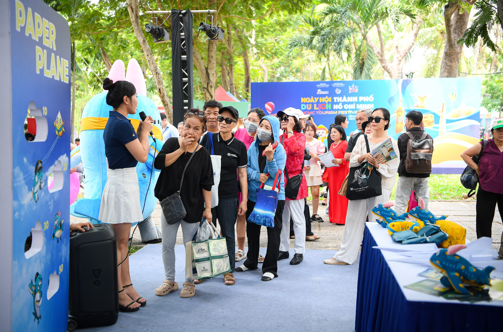 Ảnh 3 - Đông đảo khách tham quan hào hứng xếp hàng tham gia trò chơi tương tác “Paper Plane” tại gian hàng của Vietnam Airlines trong khuôn khổ Ngày hội Du lịch TP.HCM, góp phần tạo nên không khí sôi động cho sự k