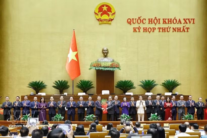 NA Chairman Tran Thanh Man presents flowers to congratule the Prime Minister, Deputy Prime Ministers, Ministers and Government members. (Photo: VNA)