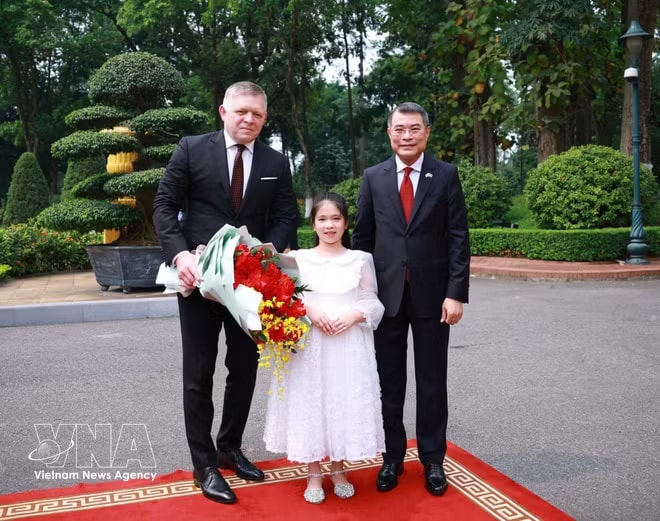 Vietnamese Prime Minister Le Minh Hung and Slovak Prime Minister Robert Fico in a photo with a Vietnamese child at the welcome ceremony on April 13 morning (Photo: VNA) vnanet-lmh2.jpg