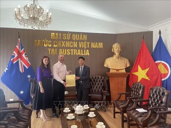 Glenn Mathews and his wife hand over the diary of Vietnamese martyr Vo Van Cong to Minister Counsellor Nghiem Xuan Hoa, representing the Embassy of Vietnam in Australia. (Photo: VNA) 