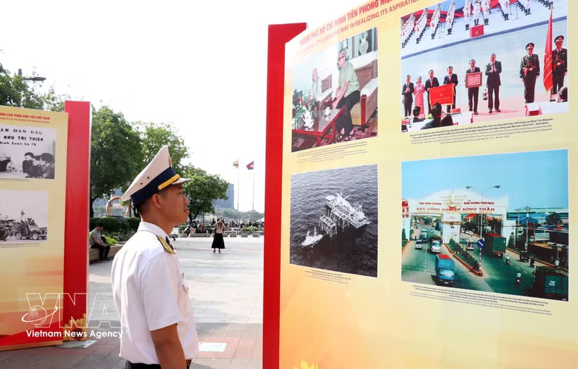A visitor looks at photos featuring people and landscape of Vietnam (Photo: VNA)