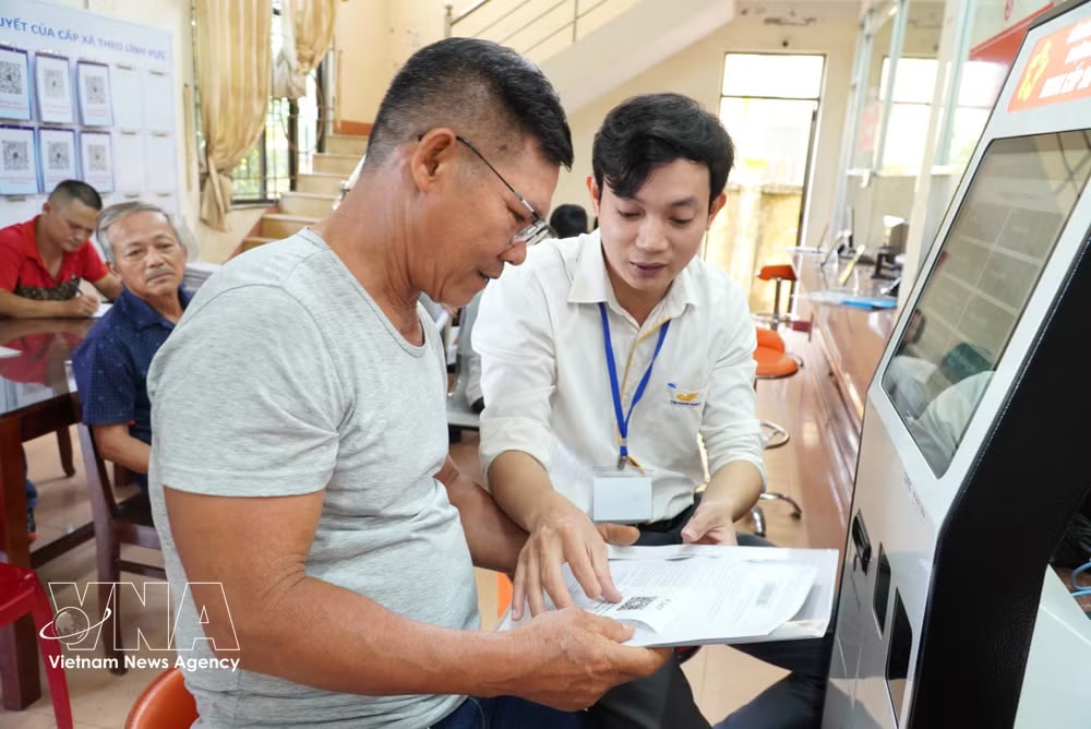 A civil servant guides citizens through administrative procedures in Quang Ngai province. (Photo: VNA) vnanet-potal-quang-ngai-tinh-gon-bo-may-hieu-qua-phuc-vu-nhan-dan-8291872-1.jpg