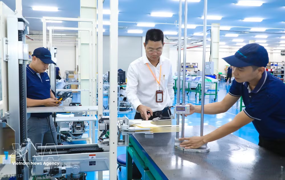Bui Anh Long, CEO of TAZMO Co., Ltd., inspects a wafer transfer robot used in the semiconductor industry. (Photo: VNA) vnanet-v.jpg