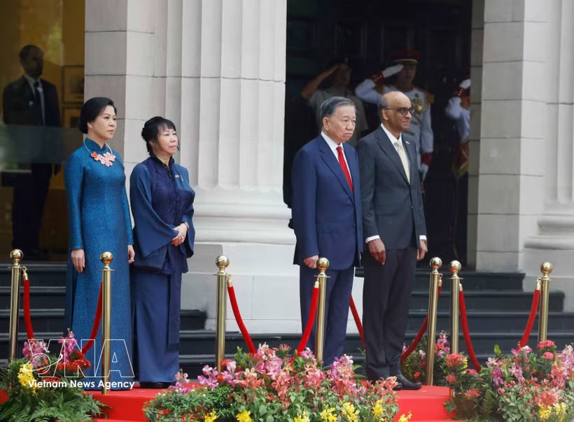 Party General Secretary and State President To Lam and Singaporean President Tharman Shanmugaratnam, together with their spouses, stand on the podium of honour as military bands perform the national anthems of Vietnam and Singapore at the welcome ceremony on May 29 morning. (Photo: VNA) 