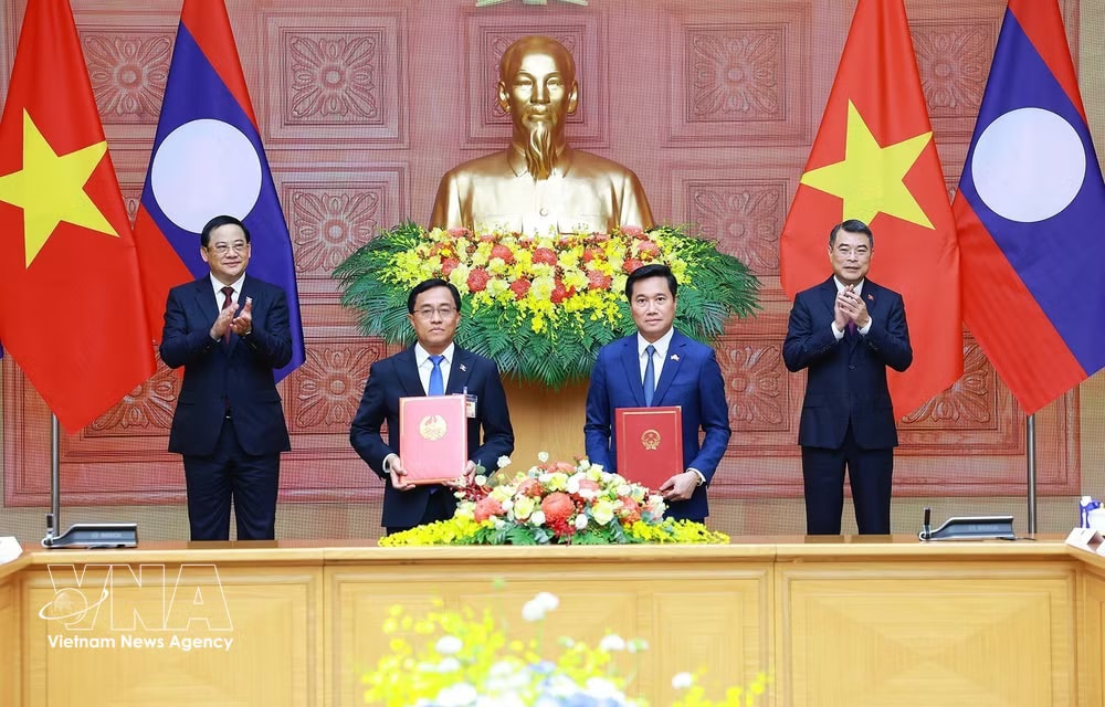 Prime Minister Le Minh Hung and Lao Prime Minister Sonexay Siphandone witness the signing of a memorandum of understanding between the Governments of Vietnam and Laos on a transport cooperation strategy for 2026–2035 (Photo: VNA) vnanet-potal-thu-tuong-le-minh-hung-va-thu-tuong-lao-sonexay-siphandone-hoi-dam-8810909-1.jpg