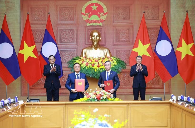Vietnamese Minister of Finance Ngo Van Tuan (R) and Lao Deputy Prime Minister and Minister of Finance Santiphab Phomvihane exchanges a cooperation agreement between their respective ministries for the 2026–2030 period under the witness of Vietnamese Prime Minister Le Minh Hung (R) and his visiting Lao counterpart Sonexay Siphandone in Hanoi on June 7, 2026. (Photo: VNA).