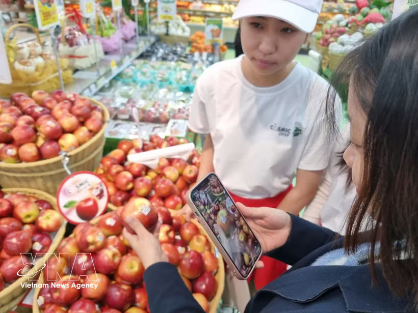 A consumer scans a QR code to access product origin information. (Photo: VNA)