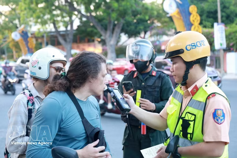 Traffic police in Khanh Hoa conduct alcohol breath tests on foreign tourists. (Photo: VNA)