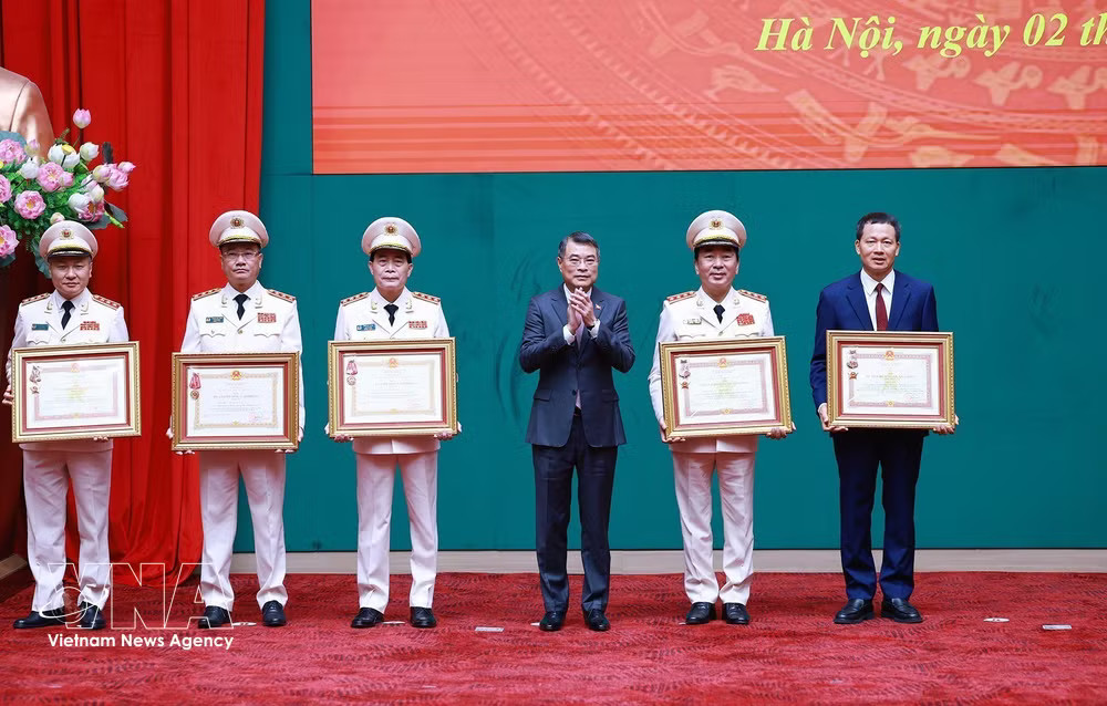 Prime Minister Le Minh Hung presents the first-class Military Exploit Order and the third-class Labour Order to individuals in recognition of their outstanding achievements at the event. (Photo: VNA) vnanet-pm-public-security.jpg