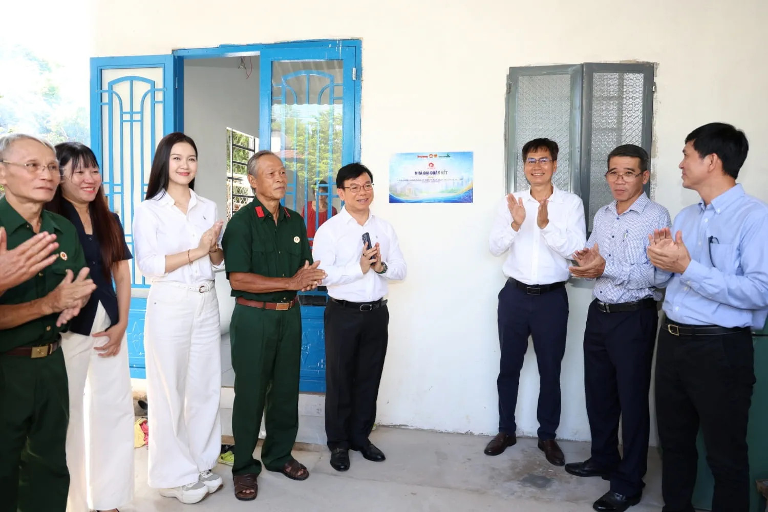 Đại diện Vietcombank, Báo Tiền Phong và chính quyền địa phương thực hiện nghi thức gắn biển Nhà tình nghĩa tại gia đình cựu chiến binh ở xã Đông Thạnh và Củ Chi. Ảnh: Hồng Nhung