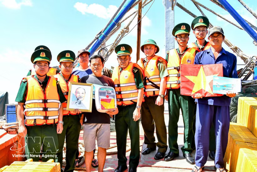 Can Tho border guards present national flags, portraits of President Ho Chi Minh and medicine cabinets to local fishermen. (Photo: VNA)