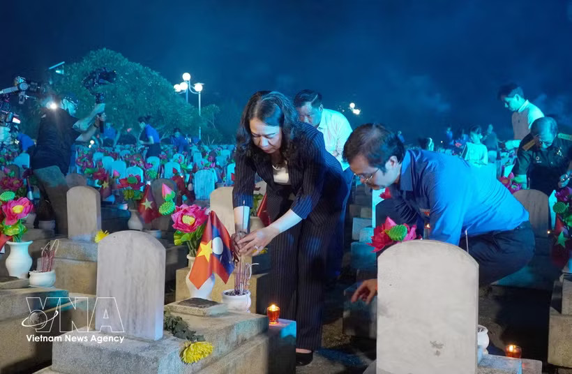 Vice State President Vo Thi Anh Xuan offers incense at the graves of fallen soldiers at the Vietnam–Laos Martyrs' Cemetery. (Photo: VNA)