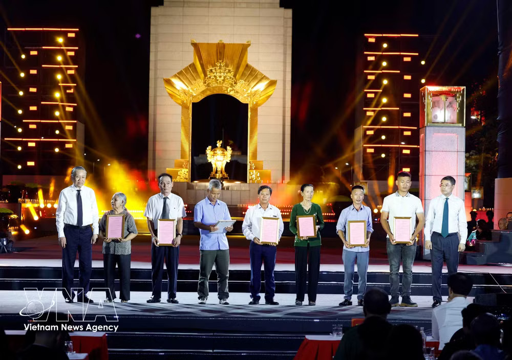 Party General Secretary and President To Lam (first, left) and Prime Minister Le Minh Hung (first, right) present DNA test result certificates to relatives of fallen soldiers' families at the Hanoi venue. (Photo: VNA) vnanet-dna.jpg