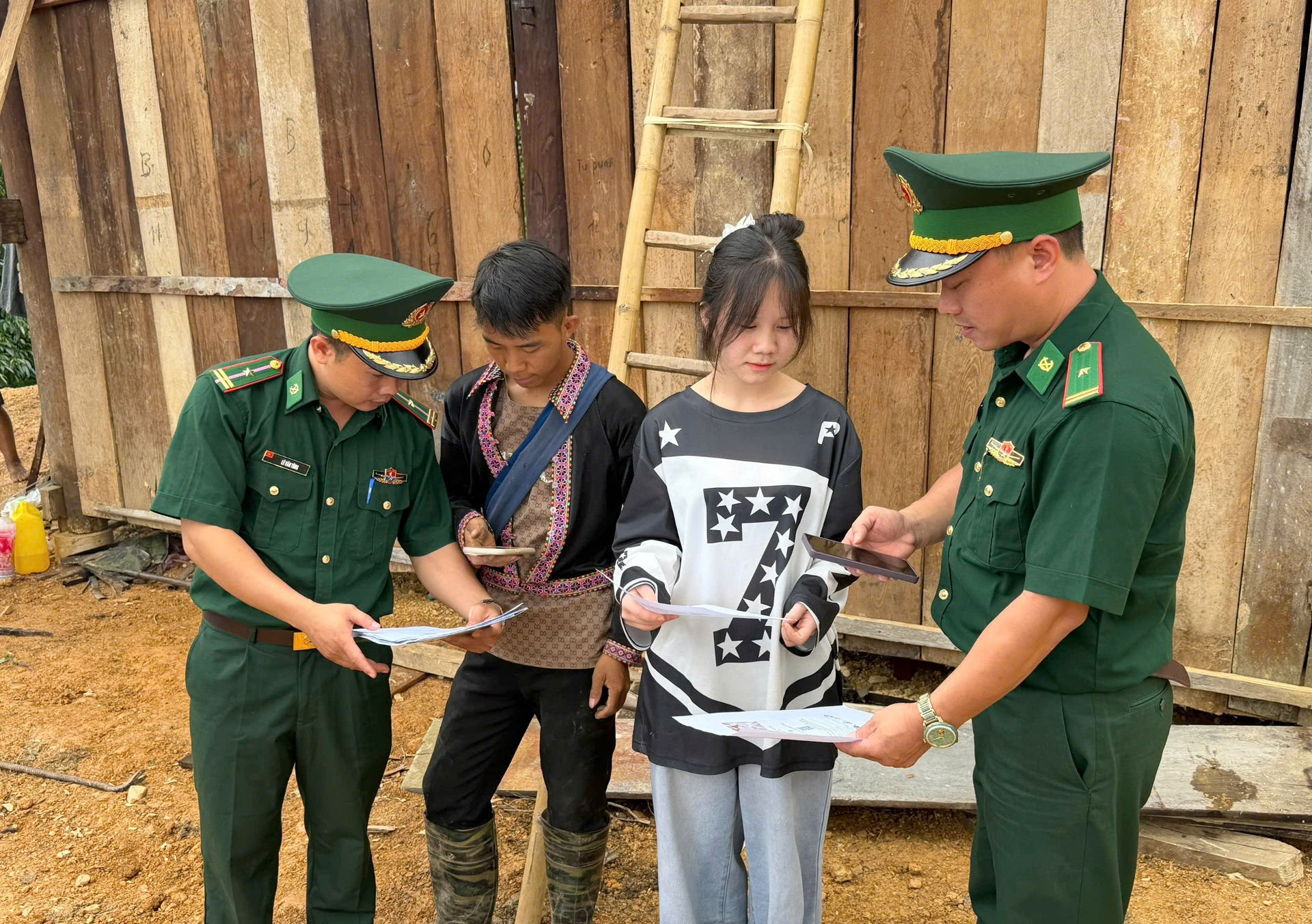 Cán bộ Đồn Biên phòng Pa Tần hướng dẫn người dân sử dụng điện thoại để quét mã 